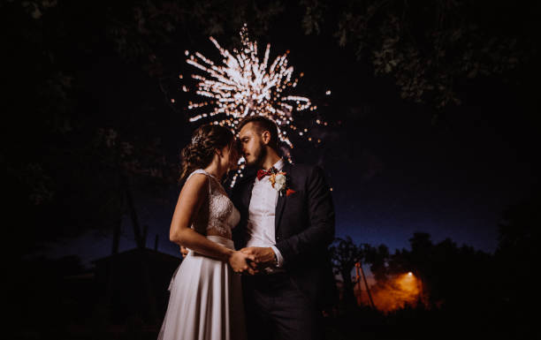 istock Wedding fireworks. Bride and groom hugging in the night on firework and salute background, wedding party 1404924493