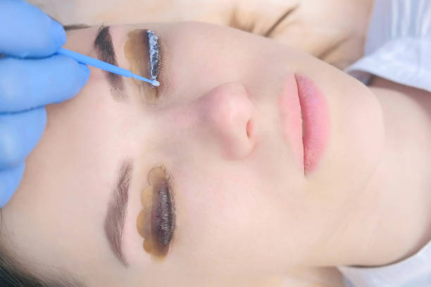 istock Beautician applying solution for lamination on lashes, lift eyelashes procedure. 1404924856