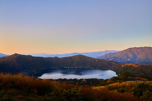 Blue lagoon in a volcano caldera between mountains, sunset with beautiful colors in the sky in Santa María del Oro Nayarit