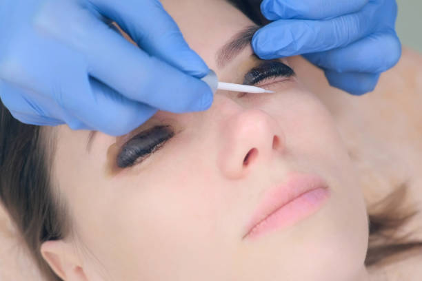 istock Beautician applying solution on lashes after lamination lift procedure. 1404924945