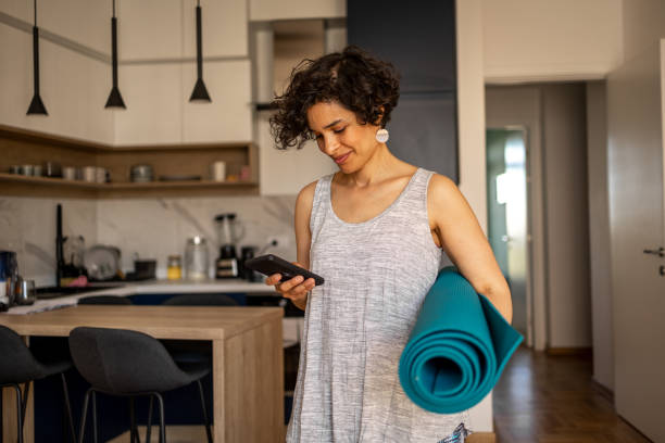 woman getting ready for her yoga practice - yoga meditating women exercise mat imagens e fotografias de stock