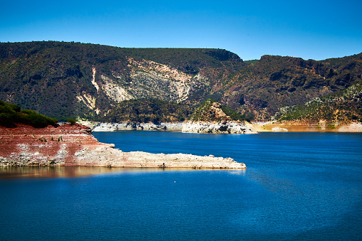 Blue water lake or dam surrounded by desert mountains on a sunny day in zimapan Hidalgo