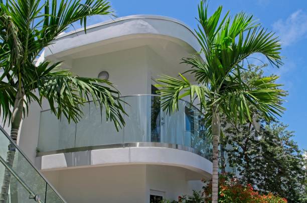 An example of Art Deco style glass balcony on a home in Key West Florida Non typical architecture found usually in Miami is this Art deco style glass balcony on a home in Key West Florida. Residential structure found in upscale neighborhood among more traditional Key West design in Spring of 2010. Tropical palm trees complement the second story deck on this tropical Florida Key home. syagrus stock pictures, royalty-free photos & images
