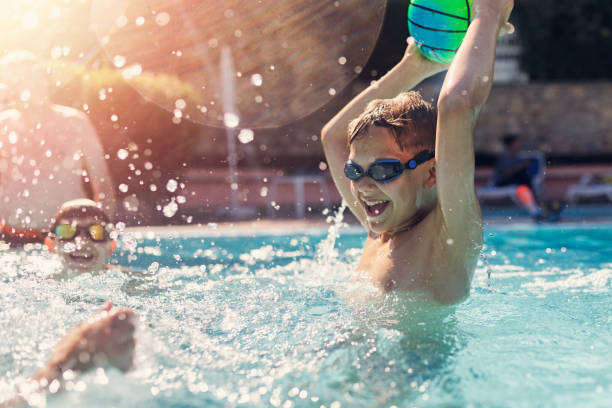 istock Kids playing ball in swimming pool 1404936045