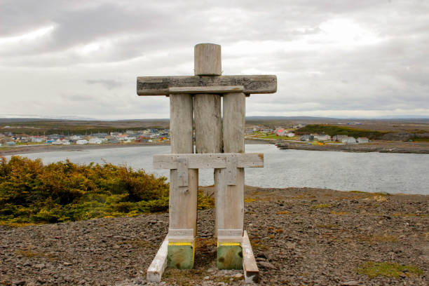 An inukshuk looking over the small community of Port au choix stock photo