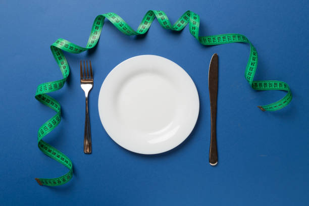 istock Green tape measure with plate on color background, top view 1404939388