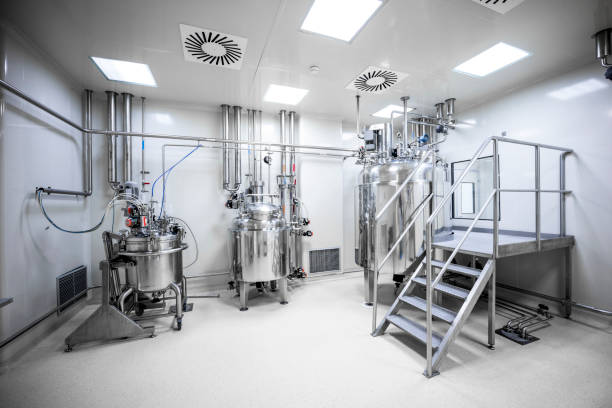 An empty laboratory with three big machines in a pharmaceutical factory One of many laboratories all white, with bright lights and without people seen inside a pharmaceutical manufacturing factory with three big machines that are one of the parts of drugs production. pharmaceutical factory stock pictures, royalty-free photos & images