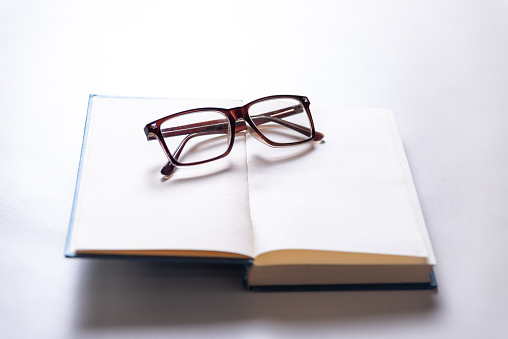 glasses on an open book, copy space, reading, myopic eyesight, education concept, selective focus