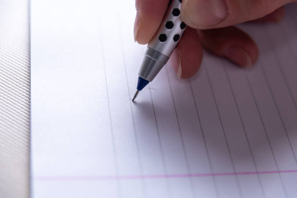 istock person writing on white paper, copy space, reading, myopic eyesight, education concept, selective focus 1404952630