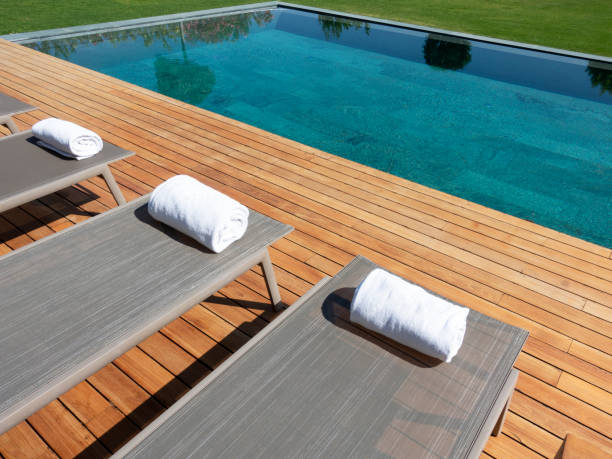 istock Deck chairs on Wooden plank floor against swimming pool 1404954426