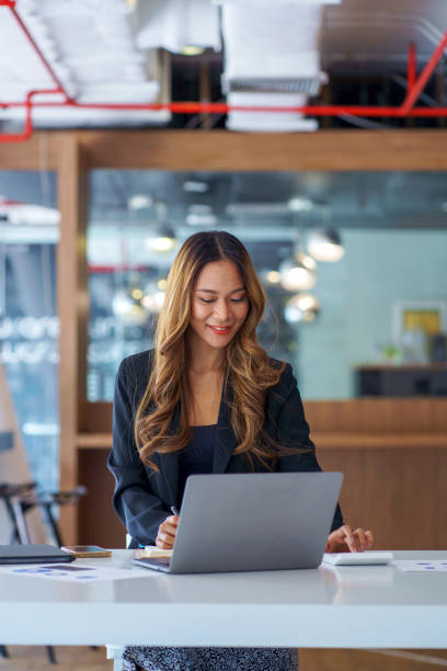 istock Beautiful young Asian woman using calculator and working in office. 1404956772