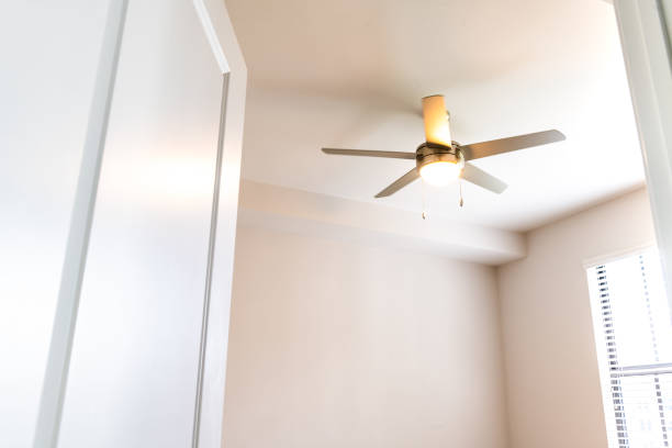 istock Empty bedroom room interior nobody looking up at lit illuminated yellow light ceiling fan open door window in new modern luxury apartment home house 1404958357