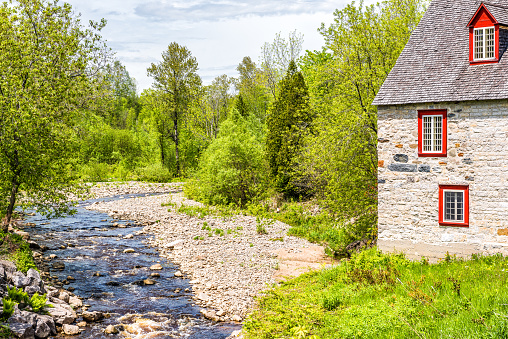 Stone cottage colorful house by river on Chemin du Roy in Quebec, Canada