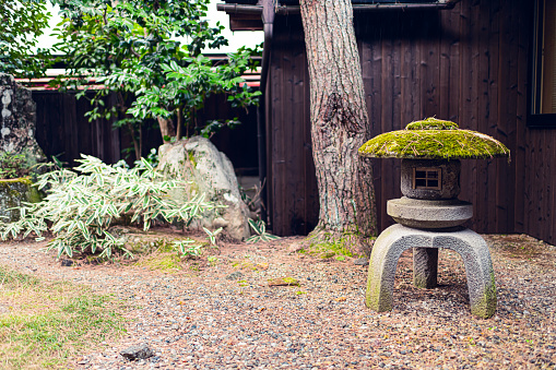 Traditional spring Japanese garden in Japan with small inside indoor with gravel stone rocks and lantern lamp at home or house