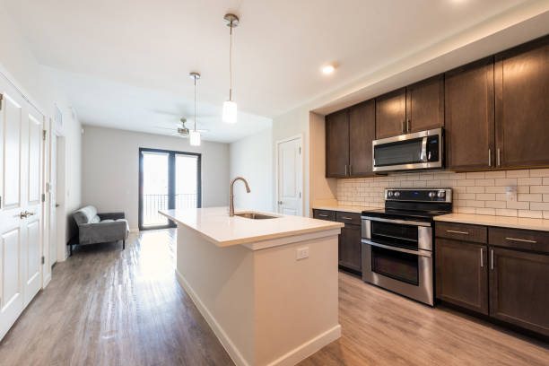 istock Empty kitchen and living room open plan modern apartment with large big island microwave oven and window balcony by sofa couch in luxury house home 1404958766