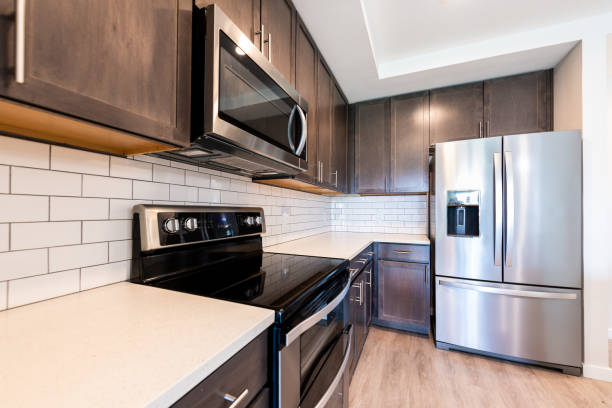 istock Nobody in modern luxury residential kitchen with tile backsplash quartz countertop by clean new fridge refrigerator stove oven and microwave appliances cabinets 1404958821