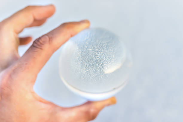 macro vue rapprochée de la main d’un homme tenant une boule de verre à lentille de cristal avec réflexion du paysage des salines de bonneville comme concept de prédiction - 16377 photos et images de collection