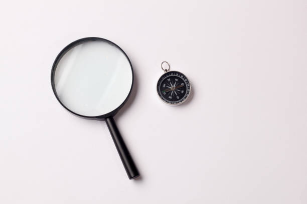 istock Top view of vintage compass with ruler and magnifying glass on white background 1404960512