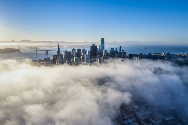 Aerial view of skyscrapers in San Francisco rising through the fog as it rolls across the city.