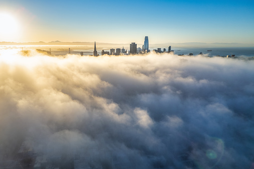 Aerial view of skyscrapers in San Francisco rising through the fog as it rolls across the city.
