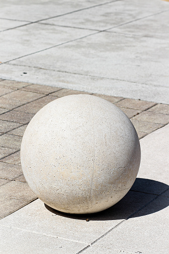 gray concrete ball architectural sculpture outside on ground