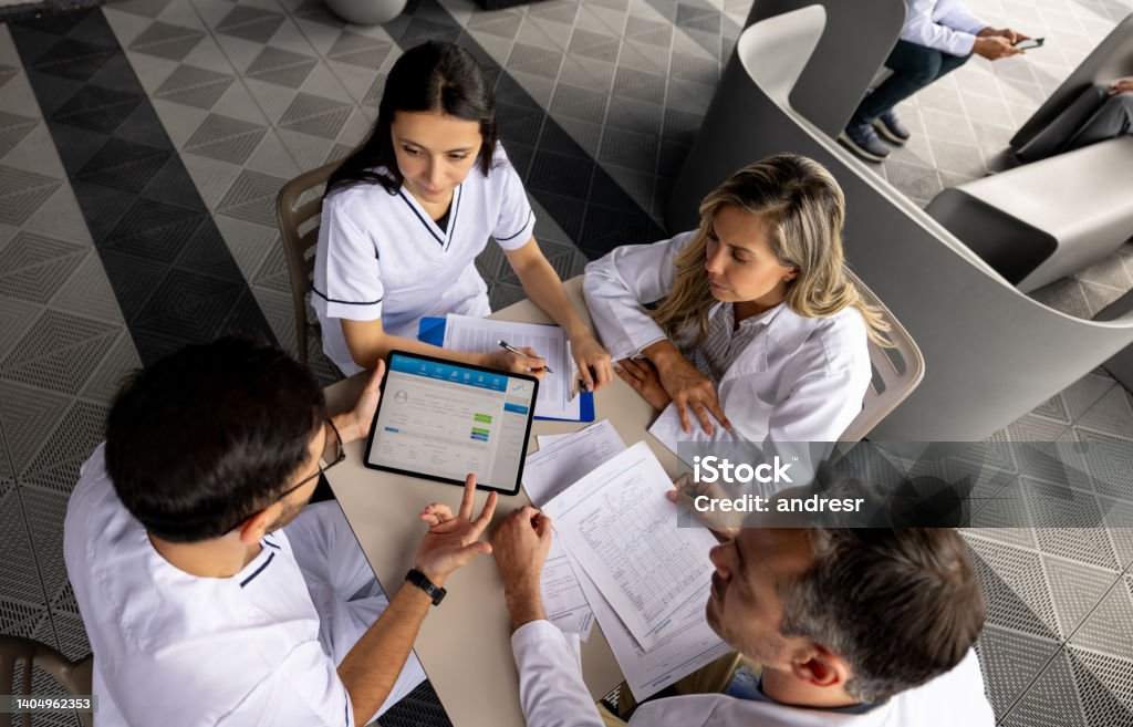 Group of healthcare workers in a meeting dicussing a patient's diagnosis Group of healthcare workers in a meeting dicussing a patient's diagnosis - healthcare and medicine concepts Healthcare And Medicine Stock Photo