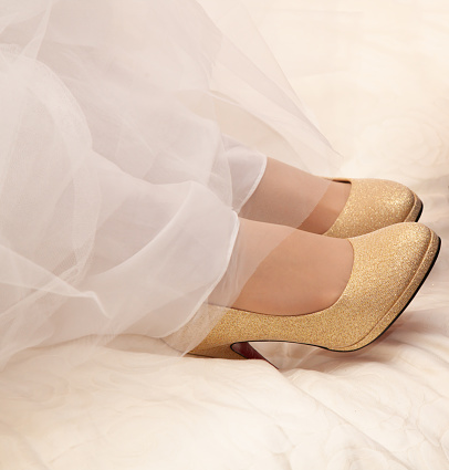 The bride puts shoes on