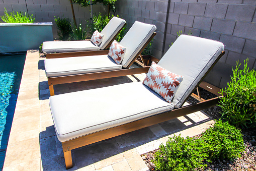 Three Adjustable Lounge Chairs With Pads By Swimming Pool