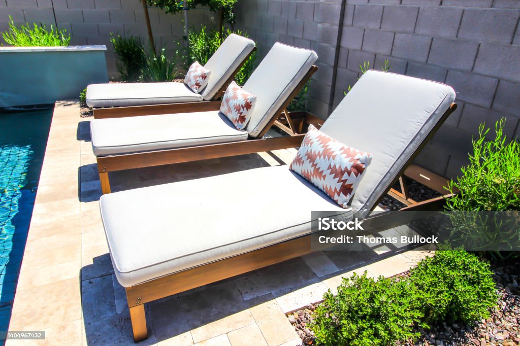 Three Adjustable Lounge Chairs By Swimming Pool Three Adjustable Lounge Chairs With Pads By Swimming Pool Lounge Chair Stock Photo