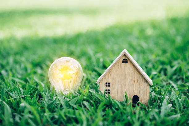 istock Closeup wood model house on sunlight grass background. 1404970411