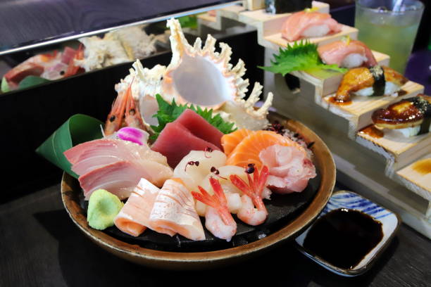 istock selective focus decorated sashimi set in a bowl with ice and conch shell another sushi set behind 1404976022
