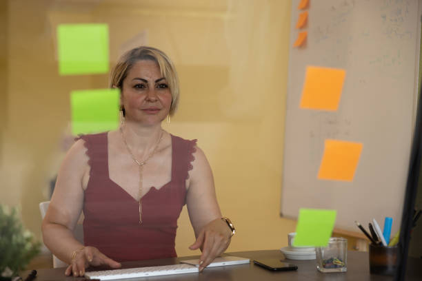 Woman in home, home office and office setting, using modern communication technology.Note: All photos visible on the wall were taken by myself.
