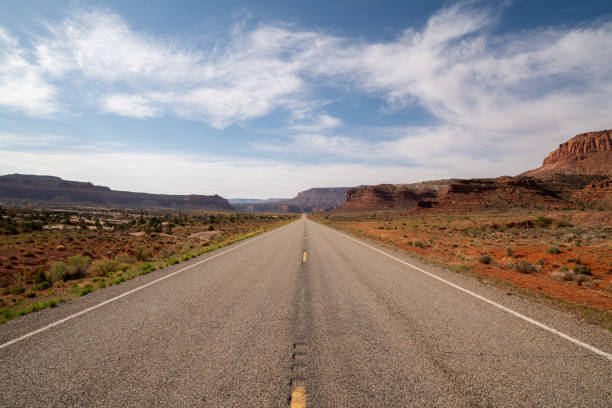 desert highway vanishes into the distance - asphalt highway desert valley imagens e fotografias de stock