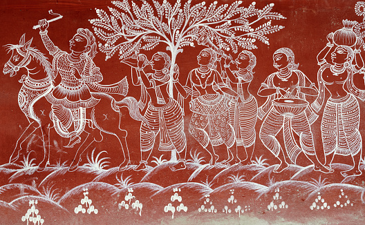 Odisha, 04-12-2022: A life-size Pattachitra styled painting (Odiya mural art) of trobal villagers dancing on outer wall of a residence at Raghurajpur craft village.