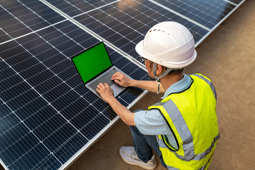 High angle view of male electrician working next to solar panels