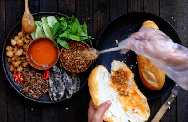 Close up woman hand prepare breakfast, Vietnamese vegan bread stuff with mushroom pie, tomato sauce, herb