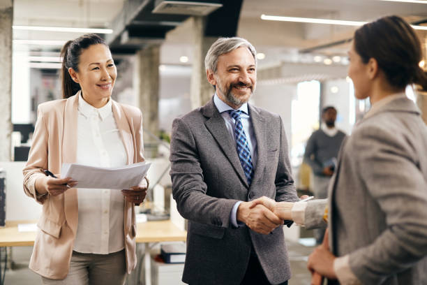 istock Happy CEO shaking hands with job candidate at corporate office. 1404987157