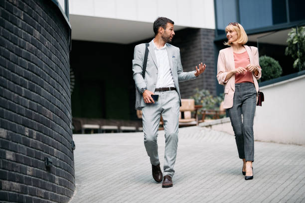 istock Full length of colleagues talking while talking on the street. 1404990001