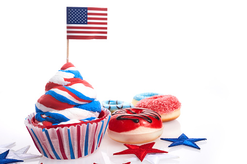 American independence day, celebration and holidays concept - glazed donut, candies, cupcakes in disposable tableware and stars