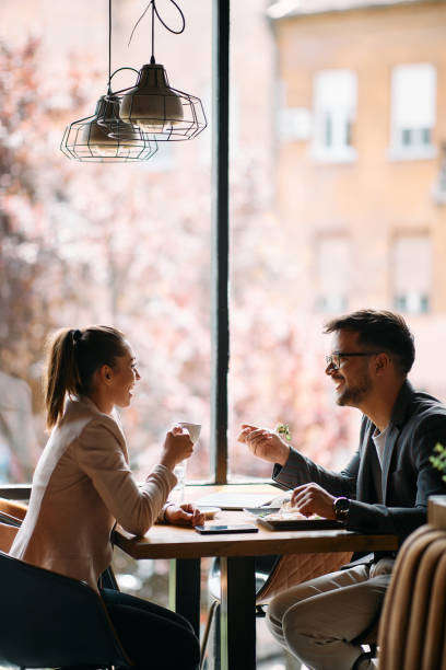 istock Young happy coworkers talking while enjoying in lunch break in a cafe. 1404990739