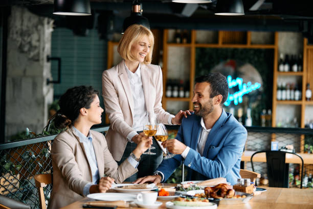 istock Happy business colleagues toasting with wine while having lunch in restaurant. 1404990751