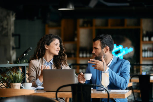 istock Happy business couple talking while drinking coffee on a meeting in cafe. 1404991881