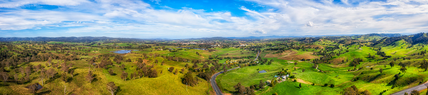 End to end wide aerial panorama of Bega Valley green pasture meadows on dairy farms, Australian agriculture.