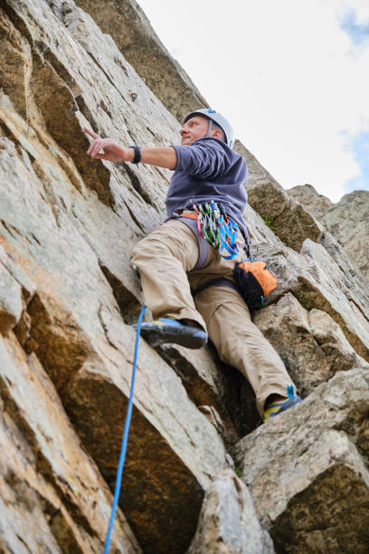 istock A Concentrated man climbing a rock wall 1404997195