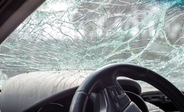 beschädigtes autofenster nach einem unfall. zerbrochene windschutzscheibe infolge eines unfalls, innenansicht. details zum innenraum der kabine, blick von der kabine aus. sichere bewegung. zerbrochene windschutzscheibe. glasriss und beschädigung. - autounfall stock-fotos und bilder