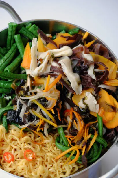 Prepare and mix to make vegan instant noodles with vegetables, raw material as string bean, mushroom, carrot, simple ingredient for vegetarian breakfast that rich fiber