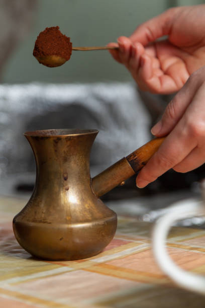 istock Hand pouring ground coffee into cezve close-up 1405001638