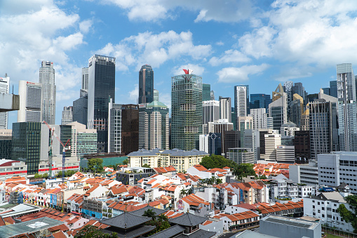 SINGAPORE, SINGAPORE - JAN 2022: Chinatown with its distinct low-rise shophouses against the backdrop of the city's financial district and skyscrapers