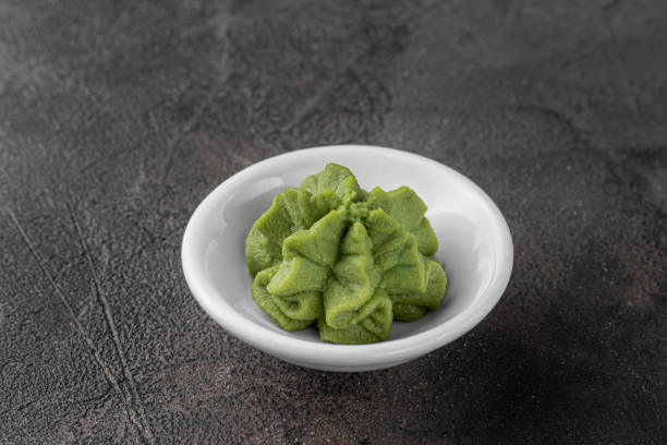 초밥을위한 와사비 소스가있는 흰색 세라믹 그릇. 어두운 회색 질감 배경, 측면보기 - wasabi 뉴스 사진 이미지