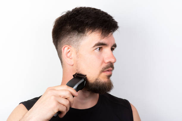 istock man shaving his beard with a trimmer 1405007756